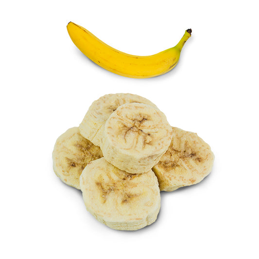 Freeze-dried banana slices beside a full regular banana